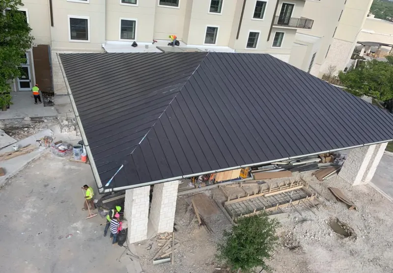 Metal roofing installation team working on a commercial building in Wellesley